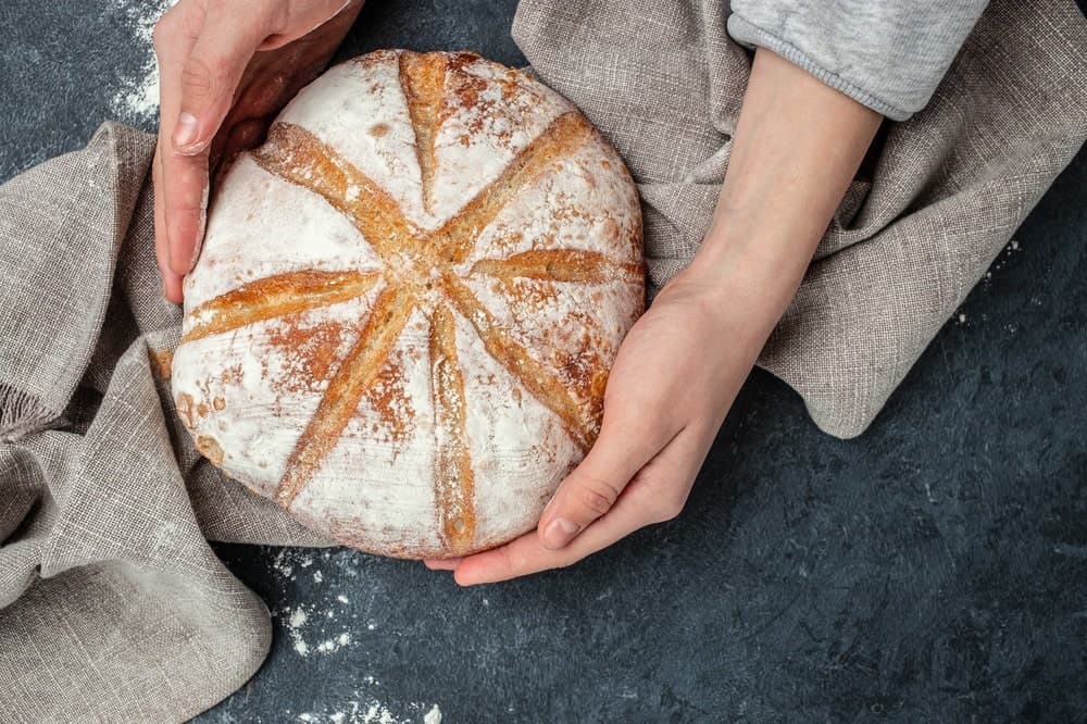 Brød og hender på en mørk kjøkkenbenk, fra Bajazzos eksisterende nettside